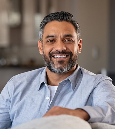 Man in blue button-up shirt smiling